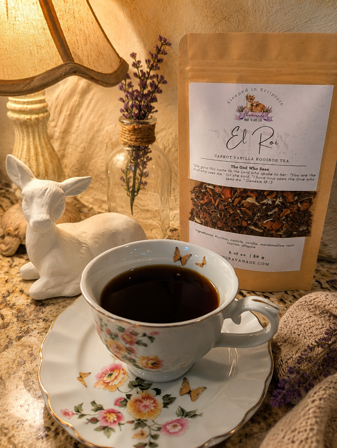 Cup of tea with a bag of El Roi tea on a decorative plate, with a lamp and decorative elements in the background.